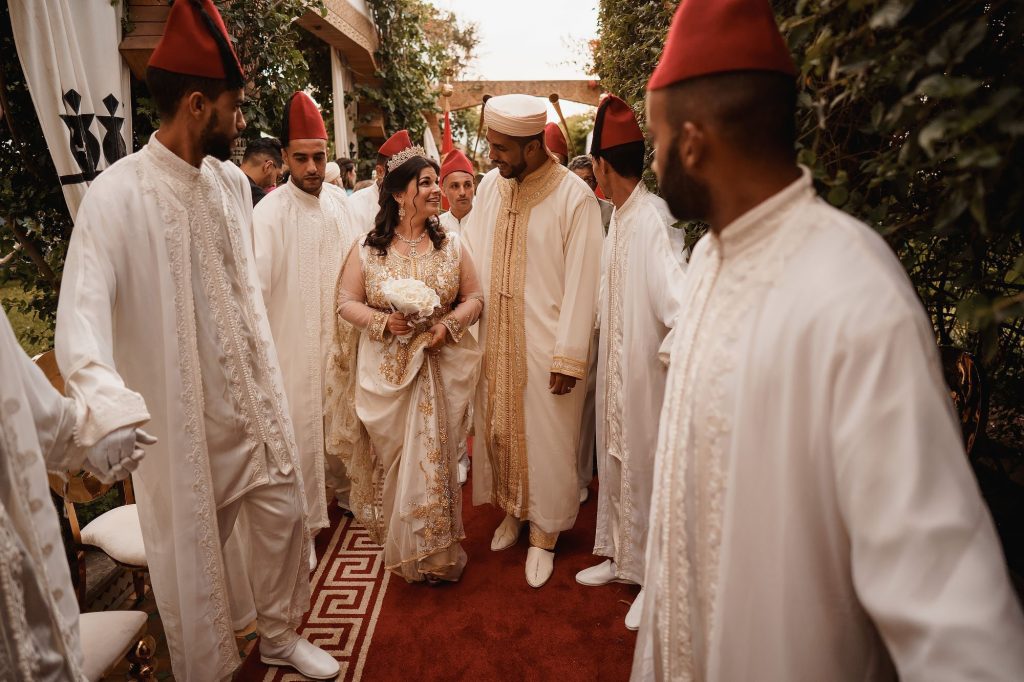 A vibrant depiction of Wedding Traditions in Morocco, featuring a bride adorned with intricate henna designs and surrounded by festive decor and joyful family members.