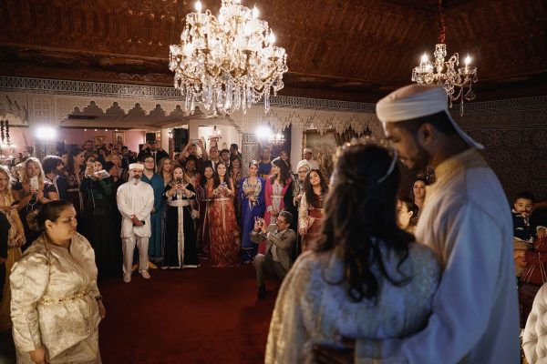 A vibrant depiction of Wedding Traditions in Morocco, featuring a bride adorned with intricate henna designs and surrounded by festive decor and joyful family members.